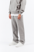 Man wearing a gray hoodie and pants on a white background